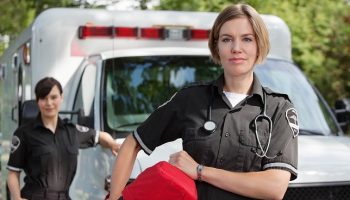 two EMTs standing in front of an ambulance