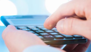 close up of man using calculator